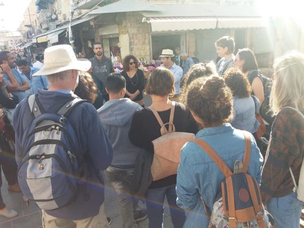 קבוצת אנשים בסיור בשוק מחנה יהודדה בירושלים