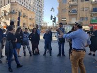 קבוצה של כ 10 אנשים עומדת ומקשיבה למדריך ברחוב בירושלים - קלאבהאוס