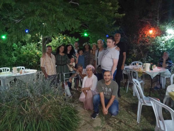 תמונה קבוצתית של כ 10 אנשים ברקע עץ גדול טבריה קלאבהאוס