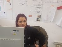 אשת צוות חדשה יושבת ליד מחשב